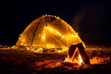 Sahildeki gece yangını. Yaz havası. Deniz kıyısında retro bir çelenkle gece kampı..