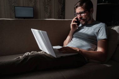 Evden uzakta çalışan gülümseyen yakışıklı bir serbest yazar. Telefonla konuşuyor..