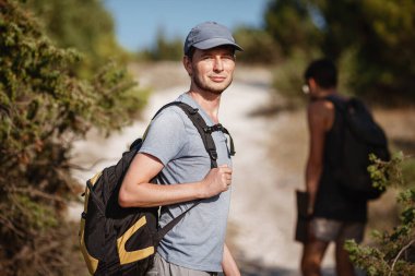 Yürüyüş yapan iki adam dağda yürüyüşe çıkar. Dağlarda dolaşmak. Spor turizminde tepeler ve tepeler. Maceranın tadını. Arka planda yürüyüşçü.
