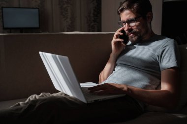 Evden uzakta çalışan gülümseyen yakışıklı bir serbest yazar. Telefonla konuşuyor..