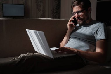 Evden uzakta çalışan gülümseyen yakışıklı bir serbest yazar. Telefonla konuşuyor..