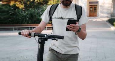 Şehrin dışında elektrikli scooter 'ı olan hippi bir adam akıllı telefon kullanıyor. Genç milenyum adamı yazın cep telefonu kiralayarak çevre taşımacılığı yapıyor.