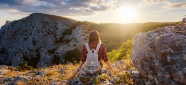 Kadın yürüyüşçü, Sunset Mountain Peak Cliff 'in manzarasının tadını çıkarıyor. Eko-turizm seyahati. Keşif Seyahat Hedefi Konsepti