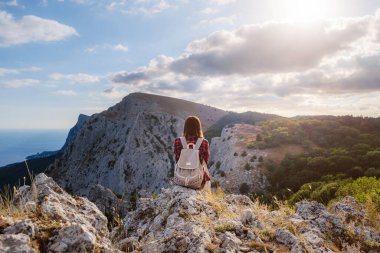 Kadın yürüyüşçü, Sunset Mountain Peak Cliff 'in manzarasının tadını çıkarıyor. Eko-turizm seyahati. Keşif Seyahat Hedefi Konsepti