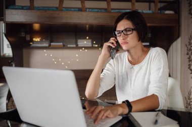 Gözlüklü genç Asyalı kız öğrenci dizüstü bilgisayar kullanıyor, internette iletişim kuruyor. Rahat ofis çalışma yeri, uzaktan çalışma, E öğrenme konsepti.
