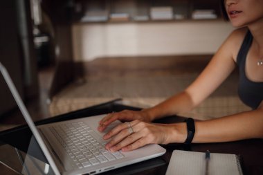 Genç Asyalı kız öğrenci dizüstü bilgisayar kullanıyor, internette iletişim kuruyor. Rahat ofis çalışma yeri, uzaktan çalışma, E öğrenme konsepti. Eller yukarı.