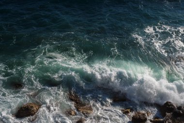 Okyanus dalgası arka planı deniz suyunu kırıyor kayalık kıyı dalgalı deniz turkuaz su gradyan köpüğü. Açık denizde büyük dalgalar. Yaz musonu. Bir deniz dalgasının beyaz tepesi.
