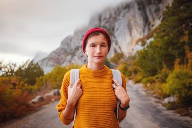 Genç ve güzel Asyalı bir hanımın dağlardaki sonbahar ormanlarında çekilmiş açık hava moda fotoğrafı. Romantik hippi kadın portresi, ılık sonbahar havası, sakin sahne. Gezgin fotoğraf serisi.