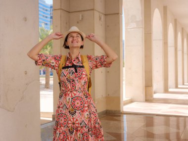 Abu Dabi 'de Qasr Al Hosn Parkı' nı keşfeden genç bir kadın. Yeşillik ve tarihi simgelerle çevrelenmiş, kentin kalbindeki sakin atmosfer ve Emirati mirasının tadını çıkarıyor..