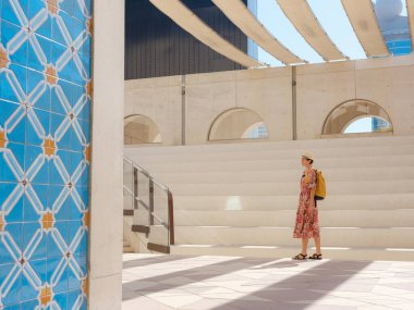 Abu Dabi 'de Qasr Al Hosn Parkı' nı keşfeden genç bir kadın. Yeşillik ve tarihi simgelerle çevrelenmiş, kentin kalbindeki sakin atmosfer ve Emirati mirasının tadını çıkarıyor..