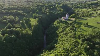 Korana yakınlarındaki yeşil tepede Ortaçağ Dreznik Grad 'ı. Yukarıdan görülen Dreznik Eski Kasabası 'nın tarihi kalıntıları Korana Nehri yakınlarındaki yemyeşil tepelere kurulmuştu. Huzurlu ve sinematik bahar manzarası