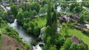 Slunj ve Korana nehirlerindeki Rastoke su değirmeni köyü. Şelaleleri, ahşap evleri, nehirleri akan sevimli Rastoke köyü. Hırvatistan 'ın göbeğindeki peri masalı bahar mevkiinin havadan görünüşü