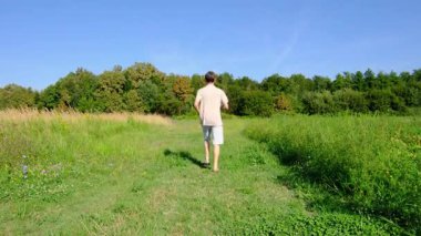 Dar bir yolda yürüyen bir adam, doğal bir manzarayla çevrili, huzurlu ve düşünceli bir atmosferi yakalıyor. Basitliğe, yalnızlığa ve doğayla bağlantıya odaklan..