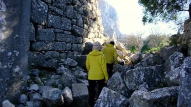 Genç gezginler antik amfitiyatroyu ve Termessos kalıntılarını keşfettiler. Yürümek, tırmanmak, manzaranın ve sıcak Türk ışığında antik tarihin tadını çıkarmak.