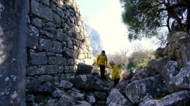 Genç gezginler antik amfitiyatroyu ve Termessos kalıntılarını keşfettiler. Yürümek, tırmanmak, manzaranın ve sıcak Türk ışığında antik tarihin tadını çıkarmak.