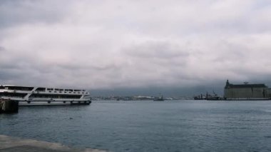 İstanbul, Türkiye - 3 Aralık 2023. Fırtınalı ve yağmurlu deniz manzarası. Dalgalar tekneye çarpar dramatik bulutlar gökyüzünü doldurur ve doğanın gücünü gösterir..