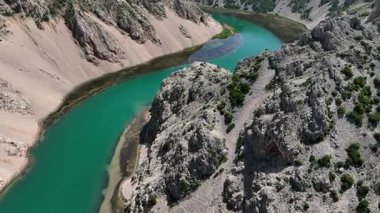 Obrovac 'tan nehir ağzı antenine kadar Zrmanja kanyonu nehri. Dolambaçlı Zrmanja nehrinin havadan çekimleri derin kanyonu, bereketli bahar renklerini ve uzak yolları kesiyor.