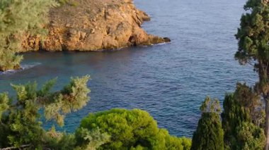 Cala Tio Ximo kıyı şeridi Aralık akşamında ele geçirildi. Sakin kış denizi, yumuşak gün batımı parıltısı, Benidorm yakınlarındaki küçük adanın huzurlu manzarası. Sessiz doğal güzellik, insan yok, sadece deniz ve gökyüzü..