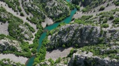 Krnjeza ve Krupa nehirlerinin birleştiği hava manzarası. Dolambaçlı Zrmanja nehrinin havadan çekimleri derin kanyonu, bereketli bahar renklerini ve uzak yolları kesiyor.