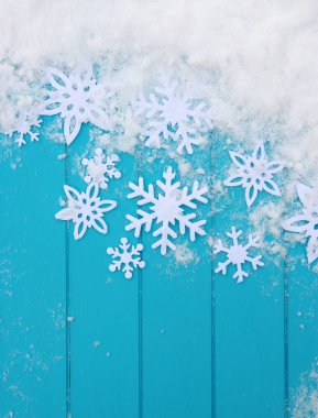 Kar taneleriyle kış şablonu. Karlı Noel arkaplanlı mavi ahşap doku.