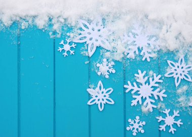 Kar taneleriyle kış şablonu. Karlı Noel arkaplanlı mavi ahşap doku.