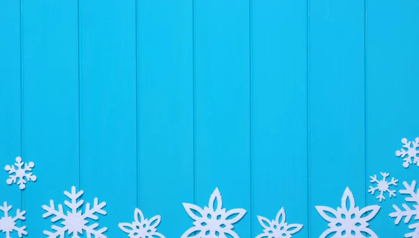 蓝色木制背景上的雪花和星星 — 图库照片
