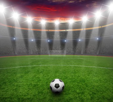 Futbol topu yeşil stadyumda, arena gece aydınlandı parlak spot ışıkları