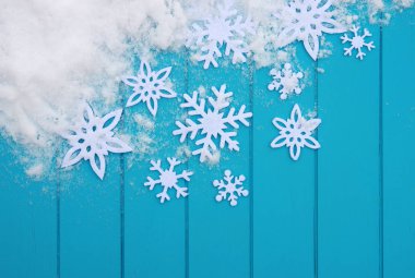 Kar taneleriyle kış şablonu. Karlı Noel arkaplanlı mavi ahşap doku.