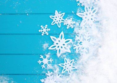 Kar taneleriyle kış şablonu. Karlı Noel arkaplanlı mavi ahşap doku.