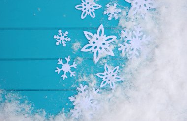 Kar taneleriyle kış şablonu. Karlı Noel arkaplanlı mavi ahşap doku.