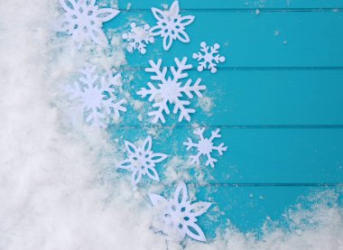 Kar taneleriyle kış şablonu. Karlı Noel arkaplanlı mavi ahşap doku.