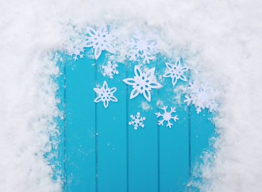 Kar taneleriyle kış şablonu. Karlı Noel arkaplanlı mavi ahşap doku.