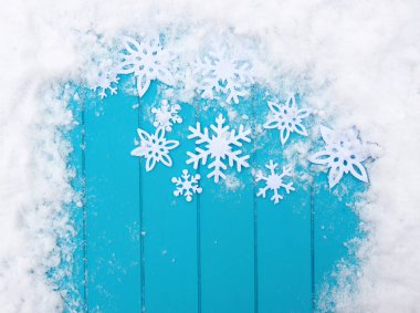 Kar taneleriyle kış şablonu. Karlı Noel arkaplanlı mavi ahşap doku.