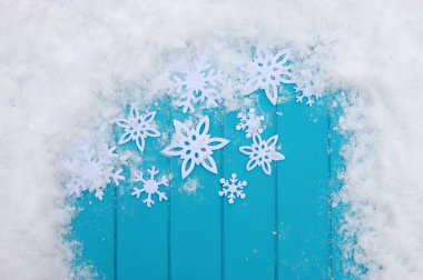 Kar taneleriyle kış şablonu. Karlı Noel arkaplanlı mavi ahşap doku.