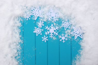 Kar taneleriyle kış şablonu. Karlı Noel arkaplanlı mavi ahşap doku.