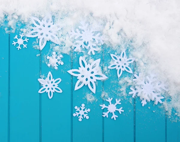 Kar taneleriyle kış şablonu. Karlı Noel arkaplanlı mavi ahşap doku.