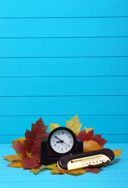 Frunze de toamnă și ceas deșteptător pe lemn — Fotografie, imagine de stoc
