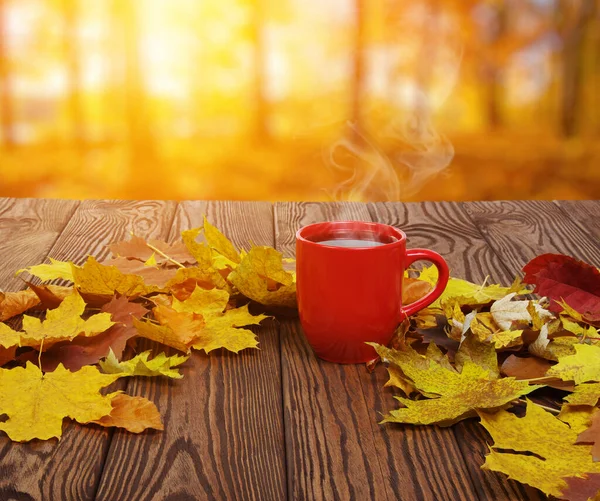 Foglie Autunnali Una Calda Tazza Caffè Fumante Tavolo Legno Sfondo — Foto Stock