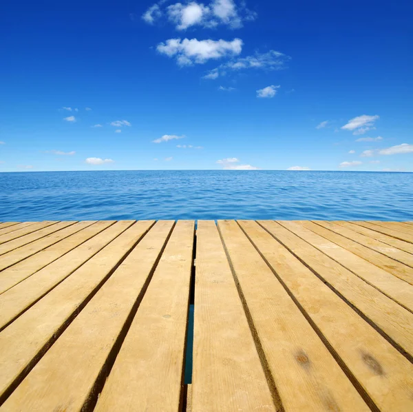 Ahşap, mavi deniz ve gökyüzü arka planı
