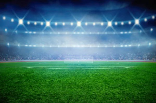 Işıklı futbol stadyumu, yeşil çimenler ve gece bulanık gökyüzü