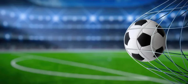 ネットとスタジアムの背景を持つ目標上のサッカーボール ストックフォト
