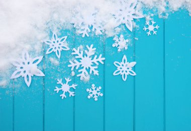 Kar taneleriyle kış şablonu. Karlı Noel arkaplanlı mavi ahşap doku.