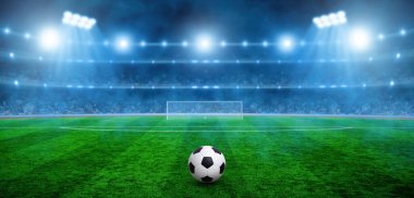 Futbol topu yeşil stadyumda, arena gece aydınlandı parlak spot ışıkları