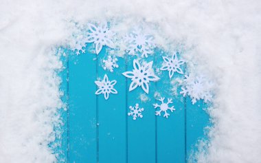 Kar taneleriyle kış şablonu. Karlı Noel arkaplanlı mavi ahşap doku.