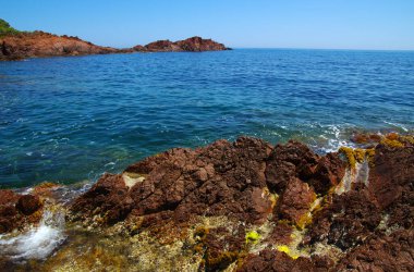 Denizin taşlı manzarası. Koyda berrak mavi su.