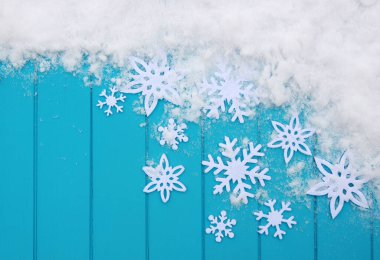 Kar taneleriyle kış şablonu. Karlı Noel arkaplanlı mavi ahşap doku.