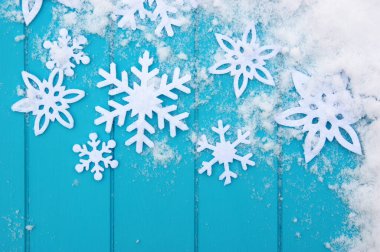 Kar taneleriyle kış şablonu. Karlı Noel arkaplanlı mavi ahşap doku.