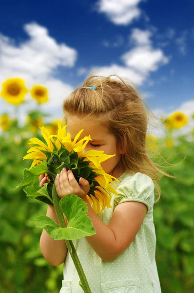 Glückliches Kleines Mädchen Das Eine Sonnenblume Auf Dem Feld Riecht — Stockfoto