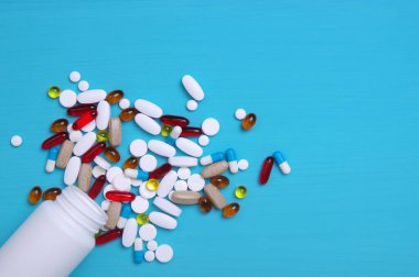 Mavi arka planda bir yığın hap.