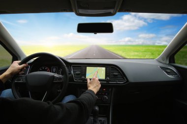 Arabanın içindeki GPS 'i kullanan bir adam eli.
